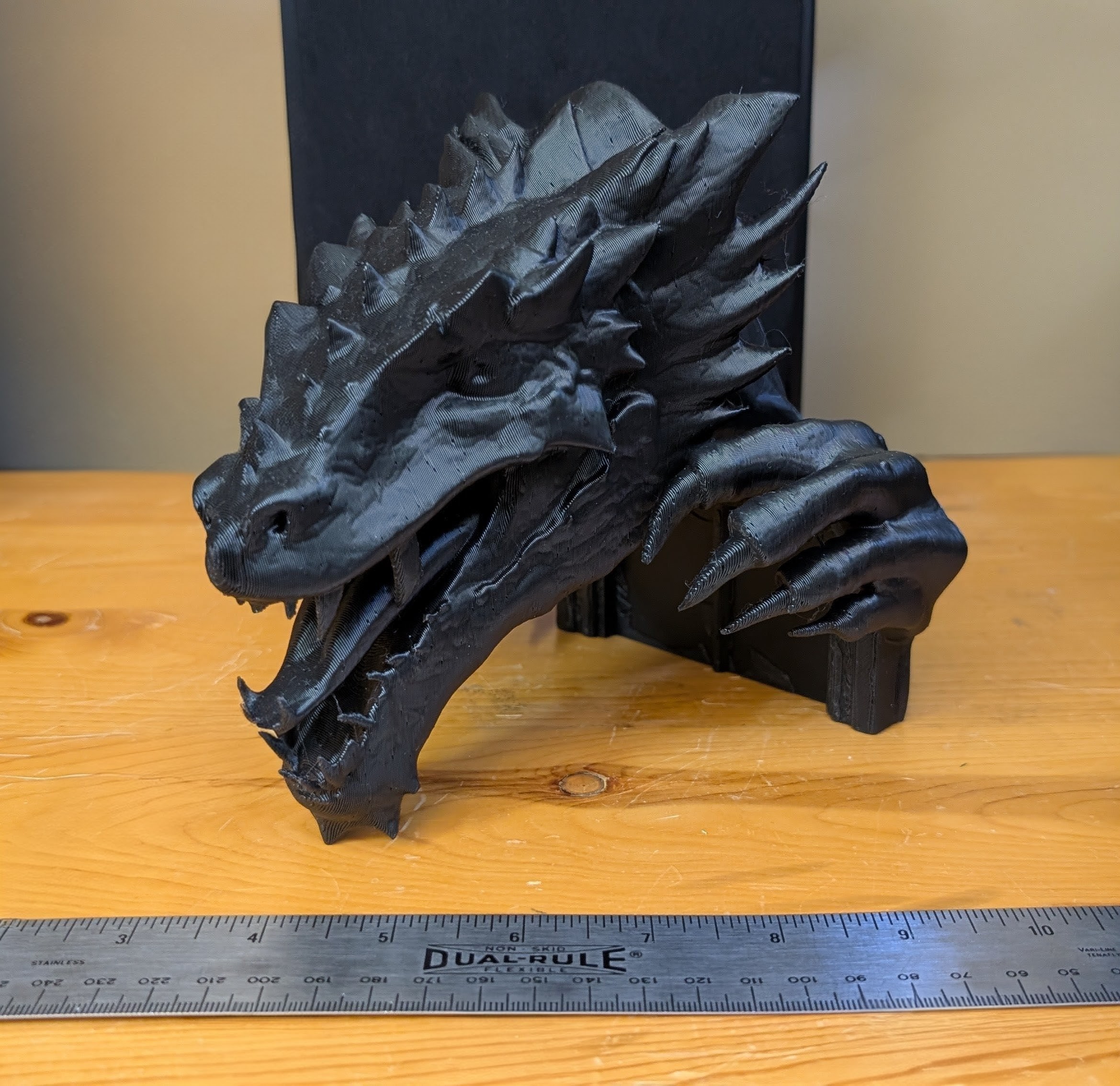 Large dragon head with reaching hands